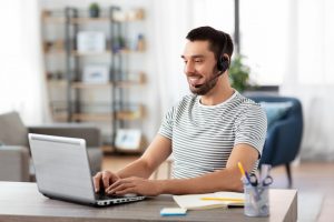 man with headset and laptop working at home